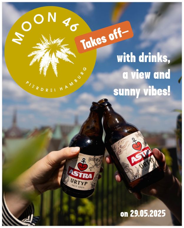 Two people clink bottles of Astra on the roof garden