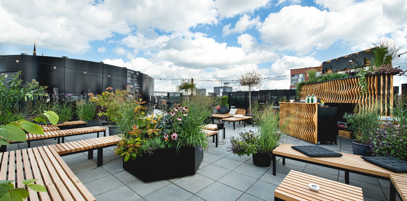 MOON 46: HafenCity roof terrace with bar, wooden furniture and many flowering plants