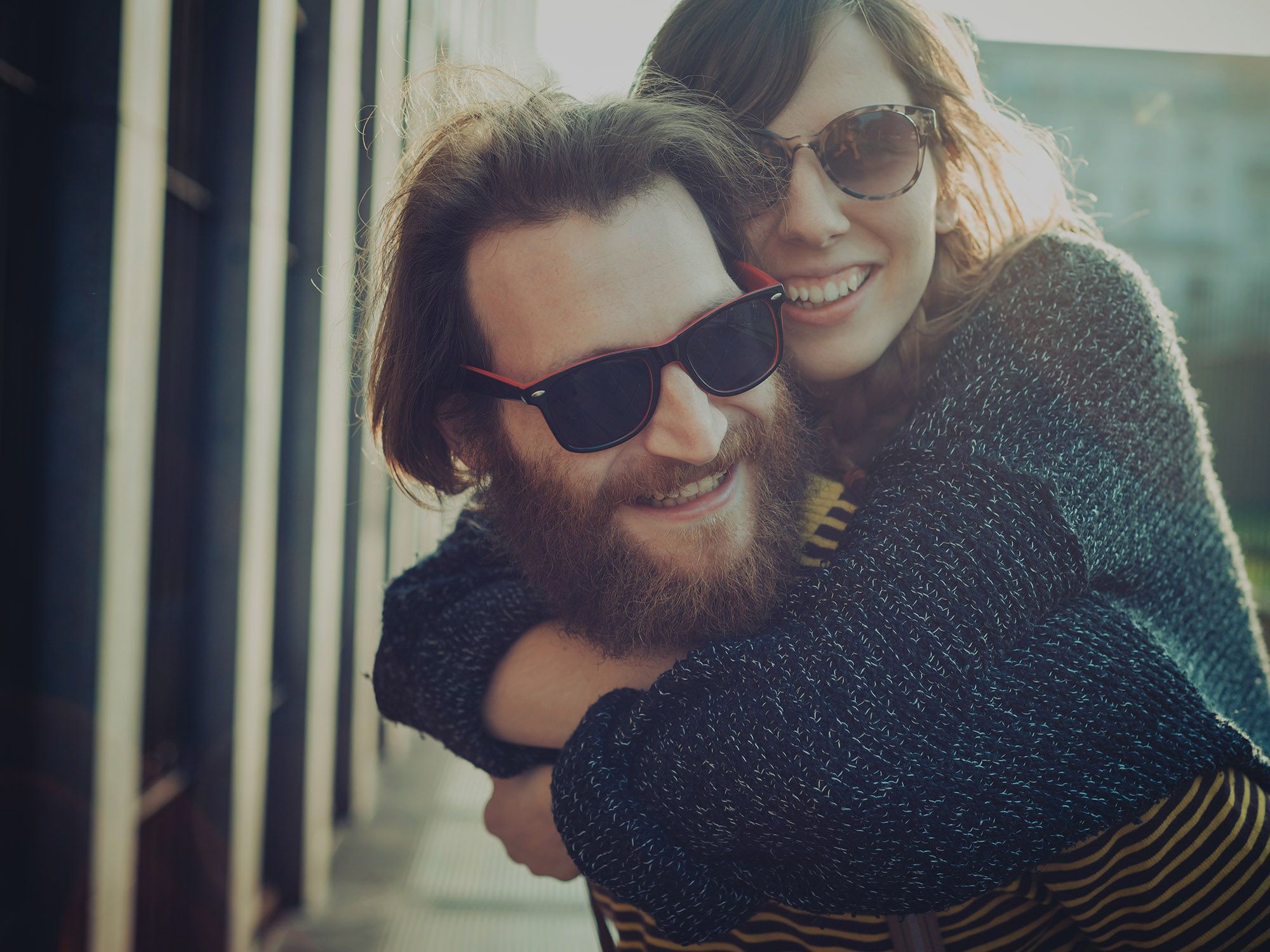 Young couple smiles at the camera, brightened by the sun