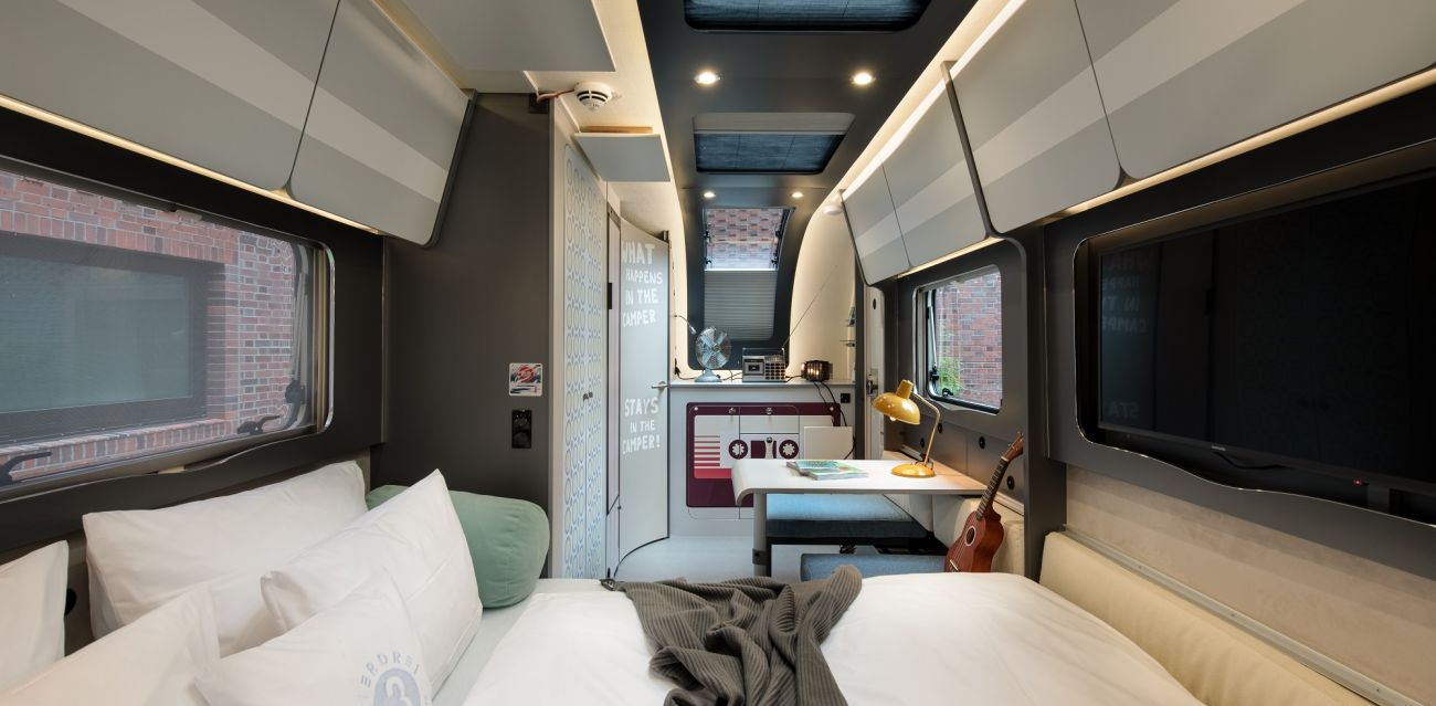 View from the pulled out bed into the camper RETRO with small table, stickers in retro style and retro decoration