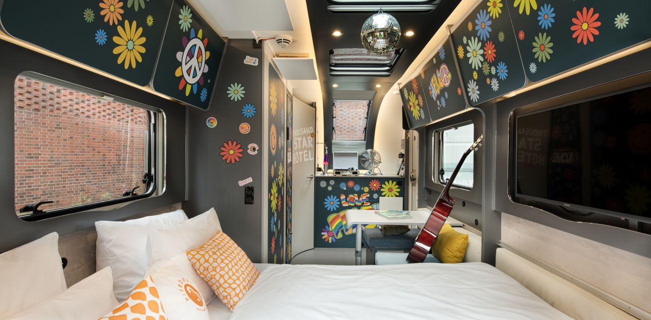 View from the extended bed to the floral interior of the camper FLOWER Coco